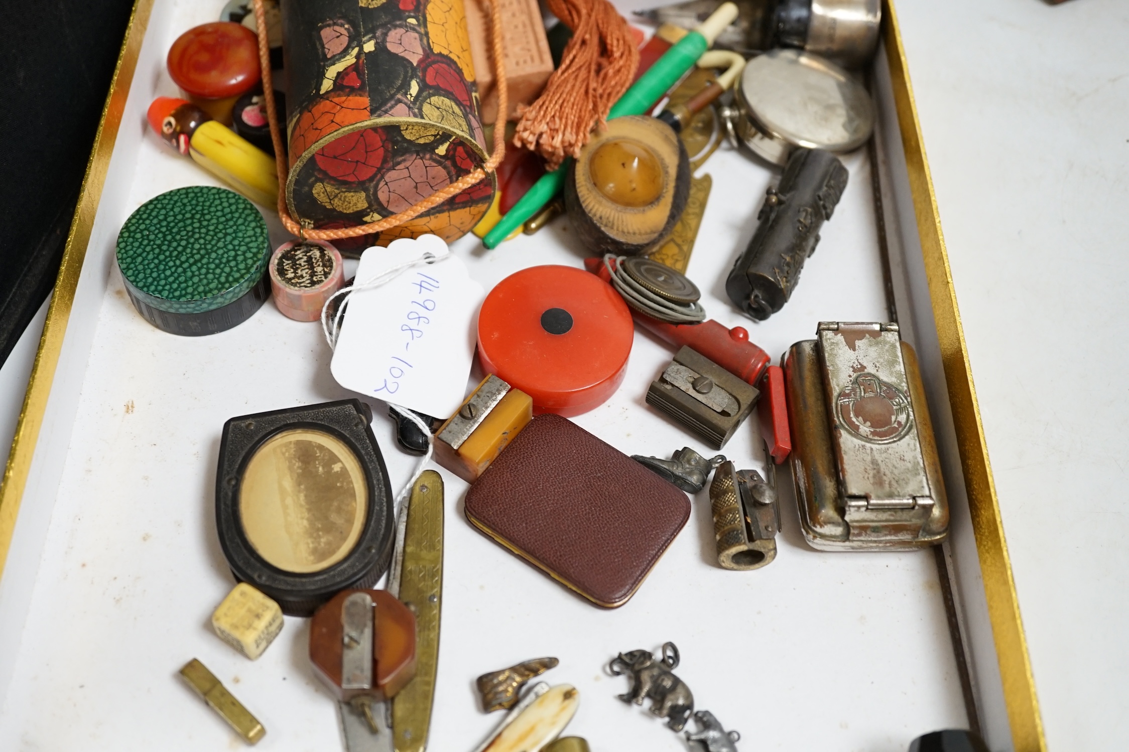 A group of mixed collectables and objects to include Bakelite boxes, pen knives, white metal charms and a gilt metal compact, etc. Condition - varies, fair